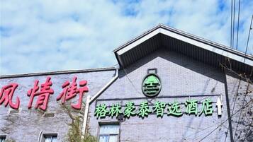 A building with a sign that reads 'Green Tree Express' and another sign with Chinese characters.
