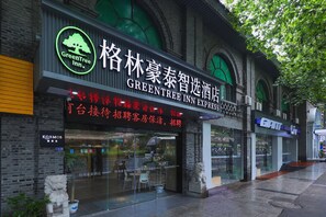 A hotel with a green tree logo, a sign for GreenTree Inn Express, and a visible entrance with a glass door. - Greentree Inn Nanjing Zhongshan Mausoleum Scenic Area Zhongling Street Subway Station Express Hotel (Nanjing)