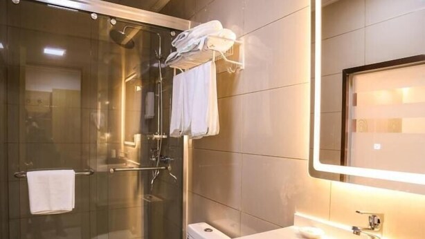 A modern bathroom with a glass-enclosed shower, a white sink, and a mirror. - Greentree Inn Nanjing Zhongshan Mausoleum Scenic Area Zhongling Street Subway Station Express Hotel (Nanjing)