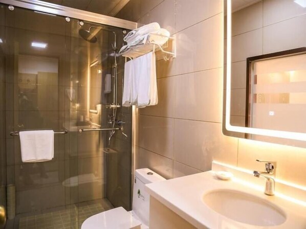 A modern bathroom with a glass-enclosed shower, a white sink, and a mirror. - Greentree Inn Nanjing Zhongshan Mausoleum Scenic Area Zhongling Street Subway Station Express Hotel (Nanjing)