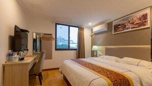 A hotel room with a bed, a desk, a chair, a window, and a painting on the wall. - Shell Wuxi Binhu District Daoxiang New Village Hotel (Wuxi)