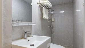 A modern bathroom with a white sink, a toilet, and a shower area. - Shell Wuxi Binhu District Daoxiang New Village Hotel (Wuxi)