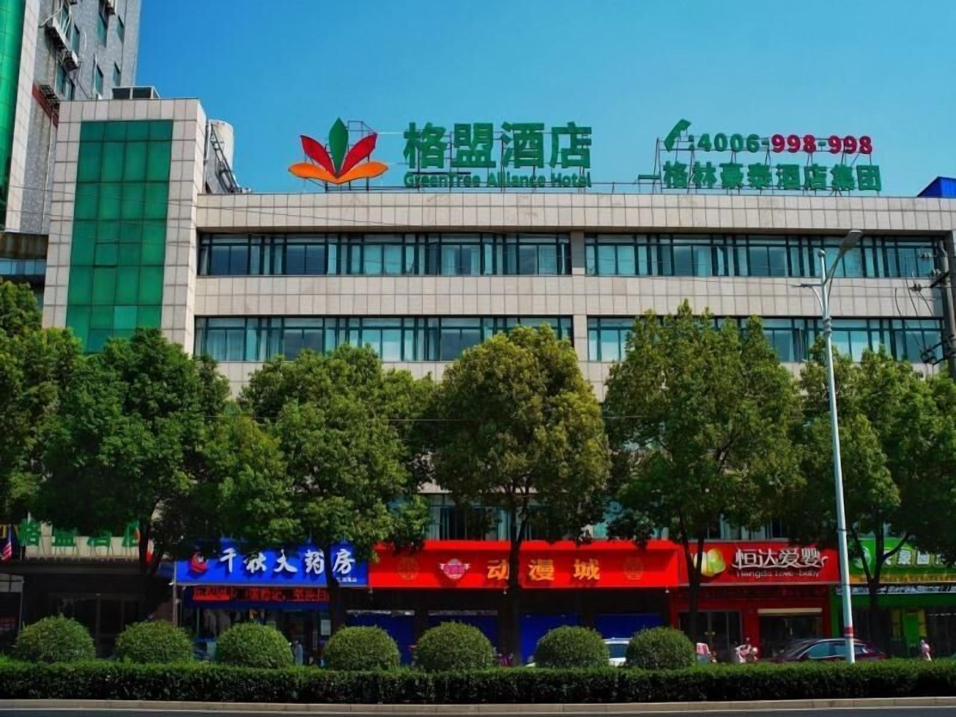Un hotel con un logotipo verde y un número de contacto.