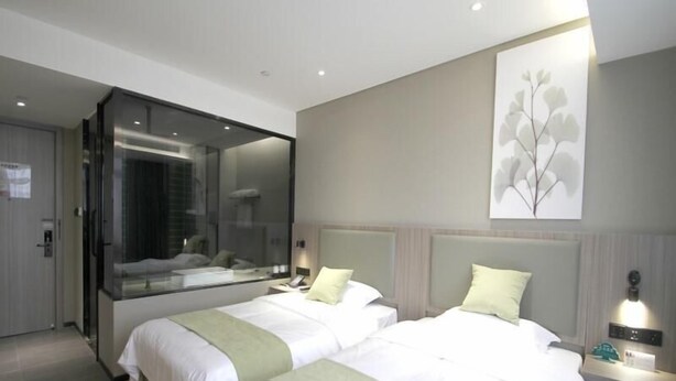 A modern hotel room with two beds, a large mirror, a wall-mounted artwork, and a bedside table with a lamp. - Greentree Inn Express Yancheng Tinghu District Environmental Protection Industrial Park (Yancheng)