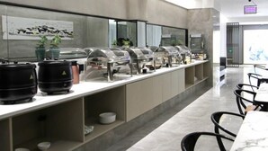 A modern buffet setup with clear food service stations, a marble-topped table, and black chairs. - Greentree Inn Express Yancheng Tinghu District Environmental Protection Industrial Park (Yancheng)