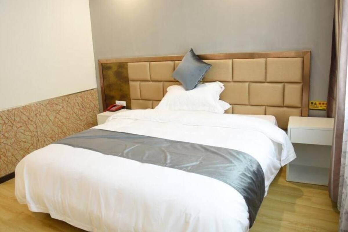 Una habitación de hotel con una cama, una mesita de noche y una pared con diseño decorativo.