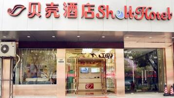 Het uiterlijk van een hotel met een opvallend bord waarop de naam in zowel Chinees als Engels staat.