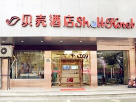 Exterior de un hotel con un letrero llamativo que muestra el nombre en chino e inglés.