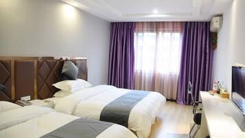 Een hotelkamer met twee bedden, een bureau en een televisie.
