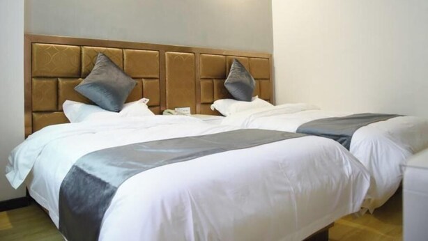A hotel room with two beds, each with a headboard and pillows. - Shell Lishui High-speed Railway Station Hotel (Lishui)