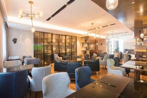 A modern hotel lobby with seating areas, a reception desk, and a large window providing a view. - Echarm Hotel Wuhan Guanggu Biology City (Wuhan)