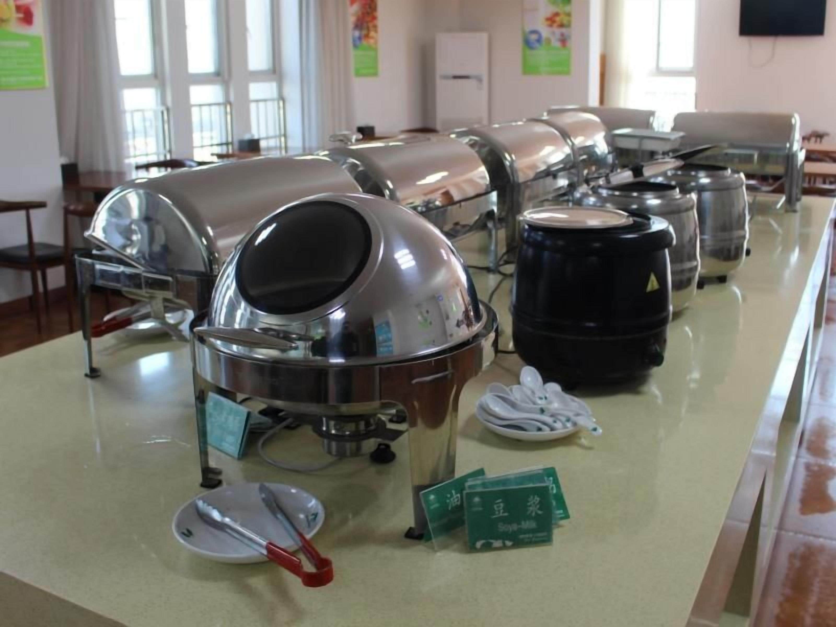 A buffet setup with multiple food dispensers and serving utensils.