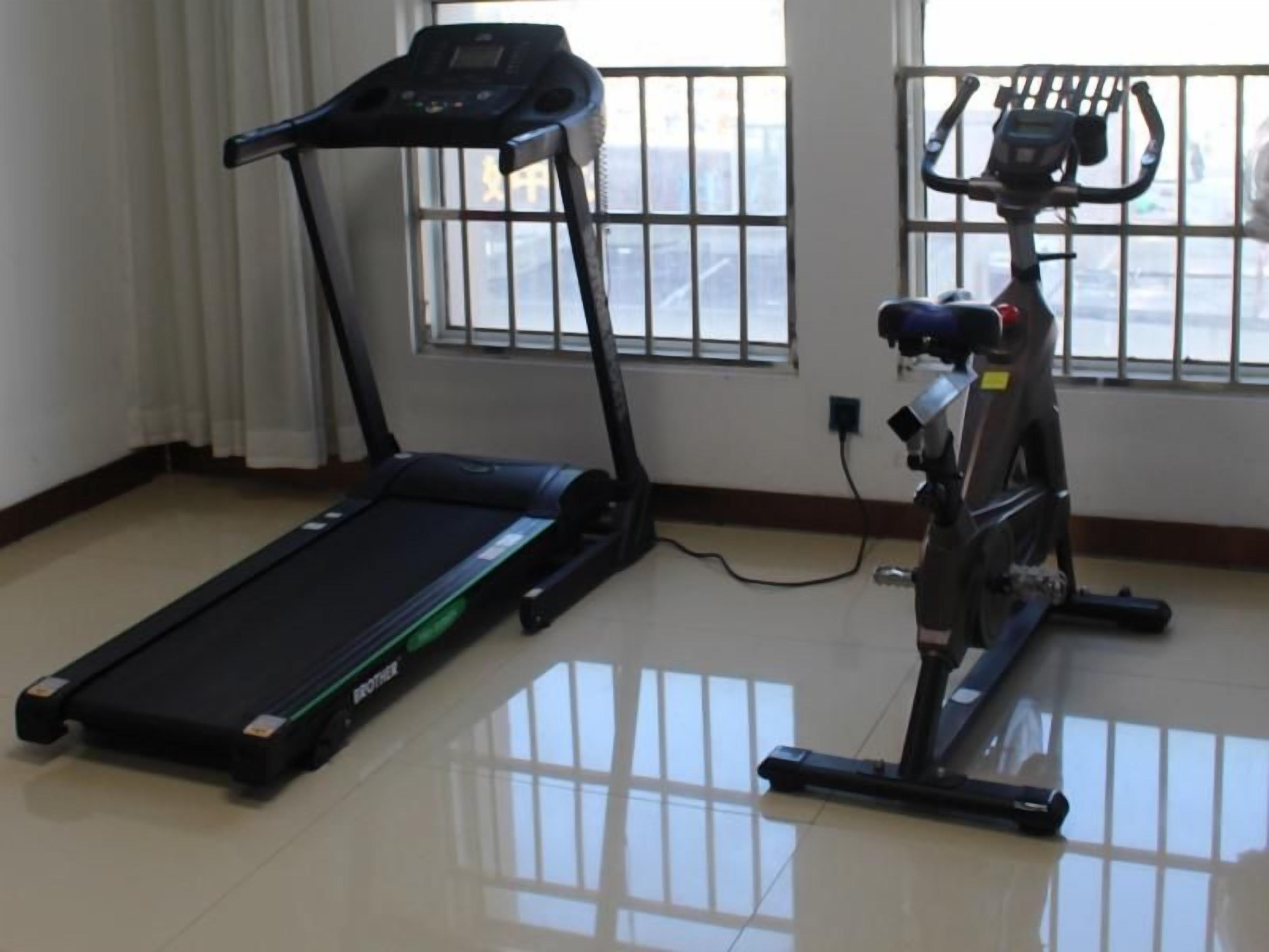 A room with a treadmill and an exercise bike.