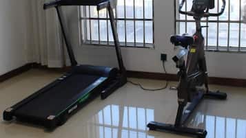 A room with a treadmill and an exercise bike.