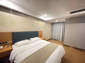 Una habitación de hotel moderna con una cama grande, una mesita de noche y un armario empotrado.