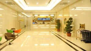 A hotel lobby with a reception desk, seating area, and potted plants. - Greentree Inn Zhenjiang Dagang New District Tonggang Road Butterfly Square (Zhenjiang)