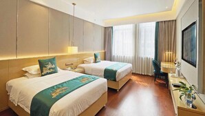 A hotel room with two beds, a desk, a TV, and a large window with curtains. - GYA Jiangsu Provinceyancheng City Oubao Liya Life Plaza Hotel (Yancheng)