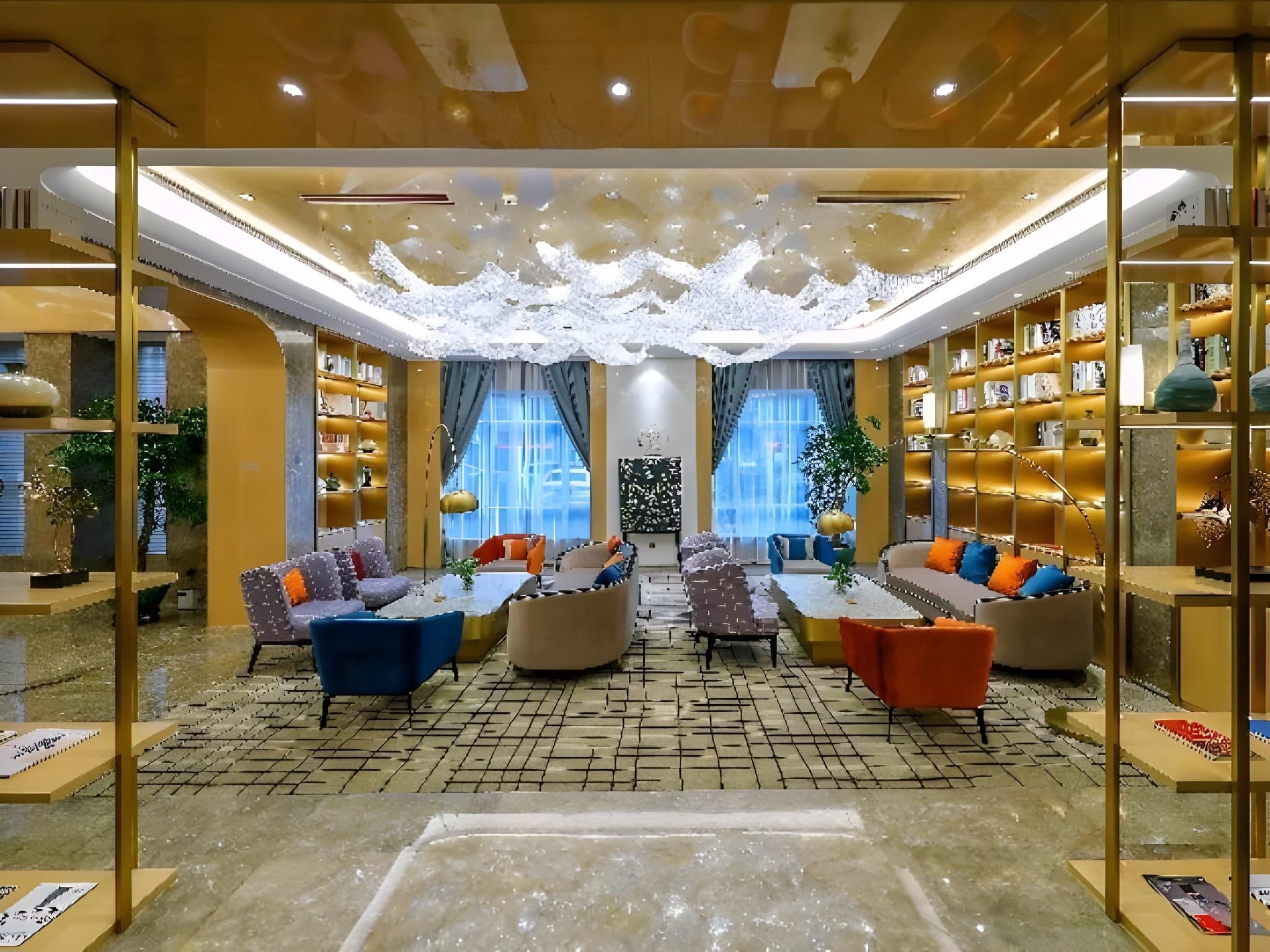 A spacious lounge area with multiple seating options, a central coffee table, and a large bookshelf filled with books.