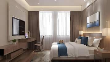 A modern bedroom with a large bed, a desk, a TV, and a flat-screen TV mounted on the wall.