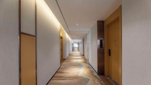 A long, narrow hotel corridor with a patterned floor, doors on both sides, and a light source at the end. - Starway Hotel (Taixing Wuyue Plaza Jichuan North Road) (Taixing)
