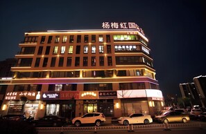 A multi-story hotel with illuminated signage and several parked cars in front. - City Comfort Inn (Wuhu)