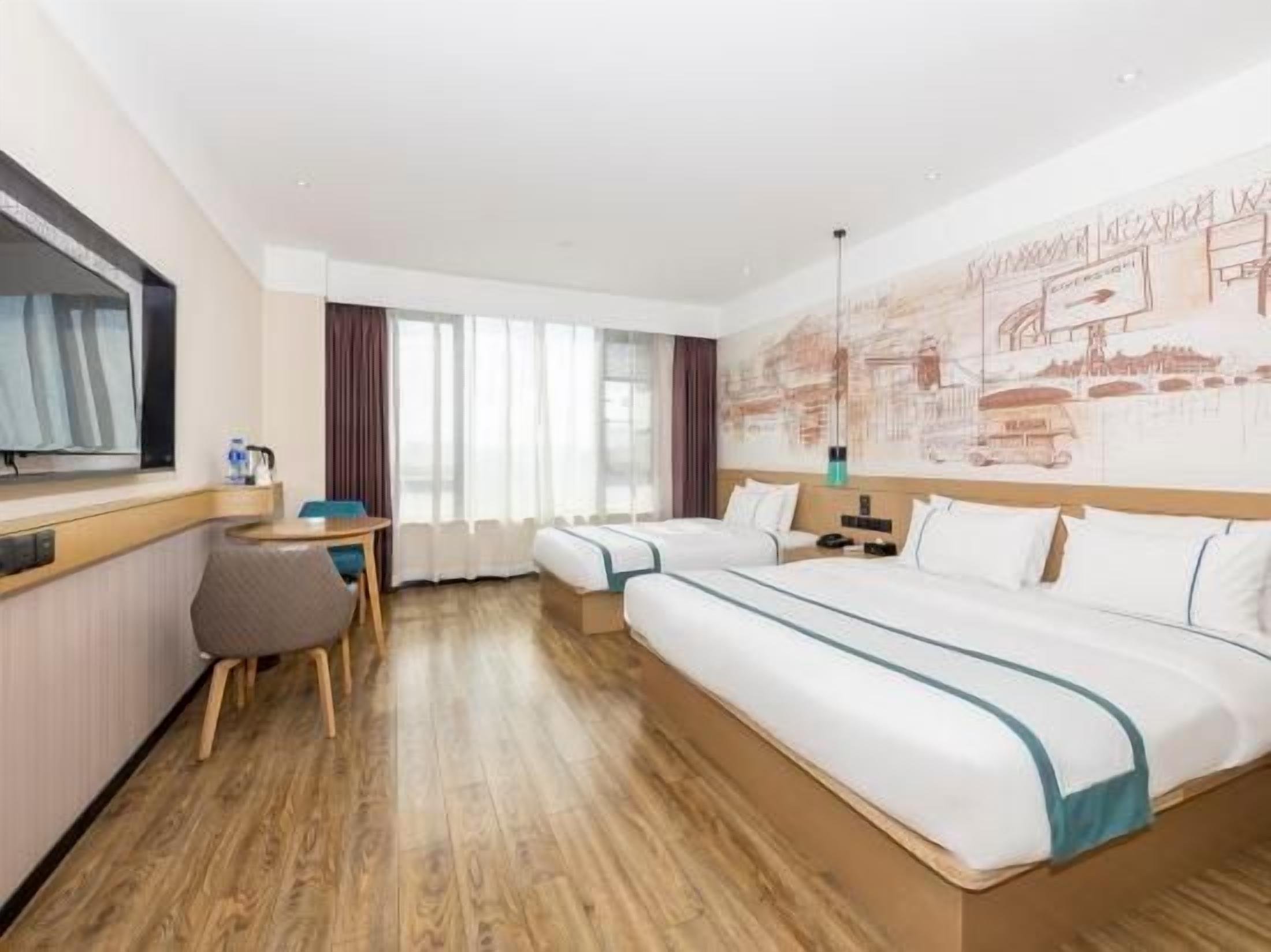 A hotel room with a large bed, a desk, and a chair.
