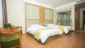 Ein Hotelzimmer mit zwei Betten, einem Holzstuhl, einem kleinen Tisch und einer Zimmerpflanze.