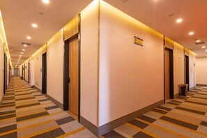 A hotel corridor with a checkered carpet, doors, and a sign on the wall. - Shell Jiangsu Kunshan Development Zone Wusongjiang South Road Hotel (Suzhou)