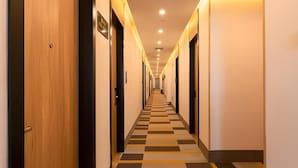 A hotel hallway with a checkered floor pattern, doors on both sides, and a ceiling with recessed lighting. - Shell Jiangsu Kunshan Development Zone Wusongjiang South Road Hotel (Suzhou)