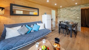 Een gezellige kamer met een bank, een eettafel en een keukenhoek.