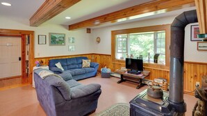 Ein gemütliches Wohnzimmer mit einem blauen Sofa, einem Kamin und einem Fernseher.