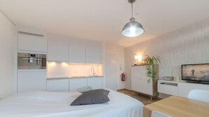 Ein modernes Schlafzimmer mit Bett, Nachttisch und einer Essecke mit Tisch und Stühlen.