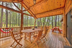 A wooden deck with a table and chairs, overlooking a forest. - Wooded Yard, Gas Grill: Lush Pinetop Retreat (Pinetop)