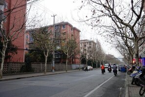 A street with buildings, trees, and parked motorcycles. - Shell Shanghai Normal University Hongcao Road Metro Station Guiping Road Hotel (Shanghai)