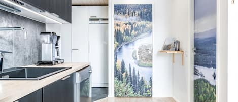 Een moderne keuken met uitzicht op een bebost rivierlandschap.