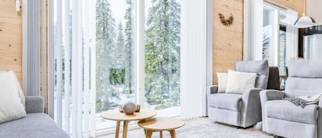 A modern living room with a grey sofa, a grey armchair, and a small wooden table.
