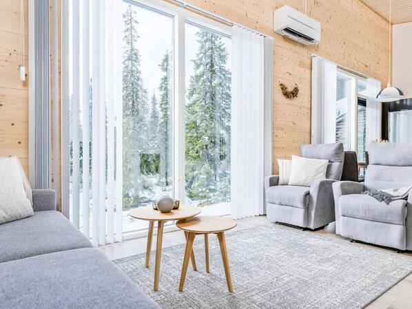 A modern living room with a grey sofa, a grey armchair, and a small wooden table.