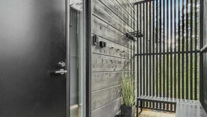 Een modern balkon met een houten vloer, een metalen hekwerk en een bloempot.