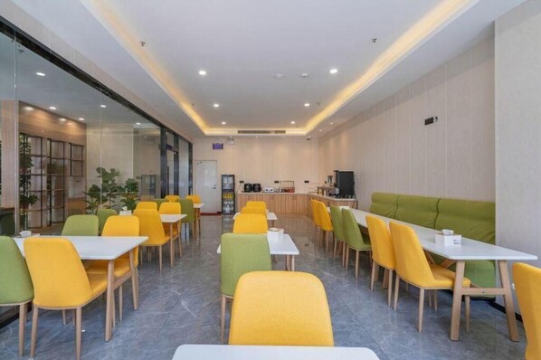 A modern dining area with yellow and green chairs, white tables, and a green sofa. - Greentree Inn Wuxi City Liangxi District Jinshan North Industrial Park West Jianghai Road Hotel (Wuxi)