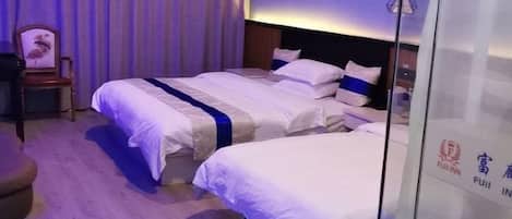 Habitación de hotel con dos camas, piso de madera, una cortina y una pared con un logotipo.