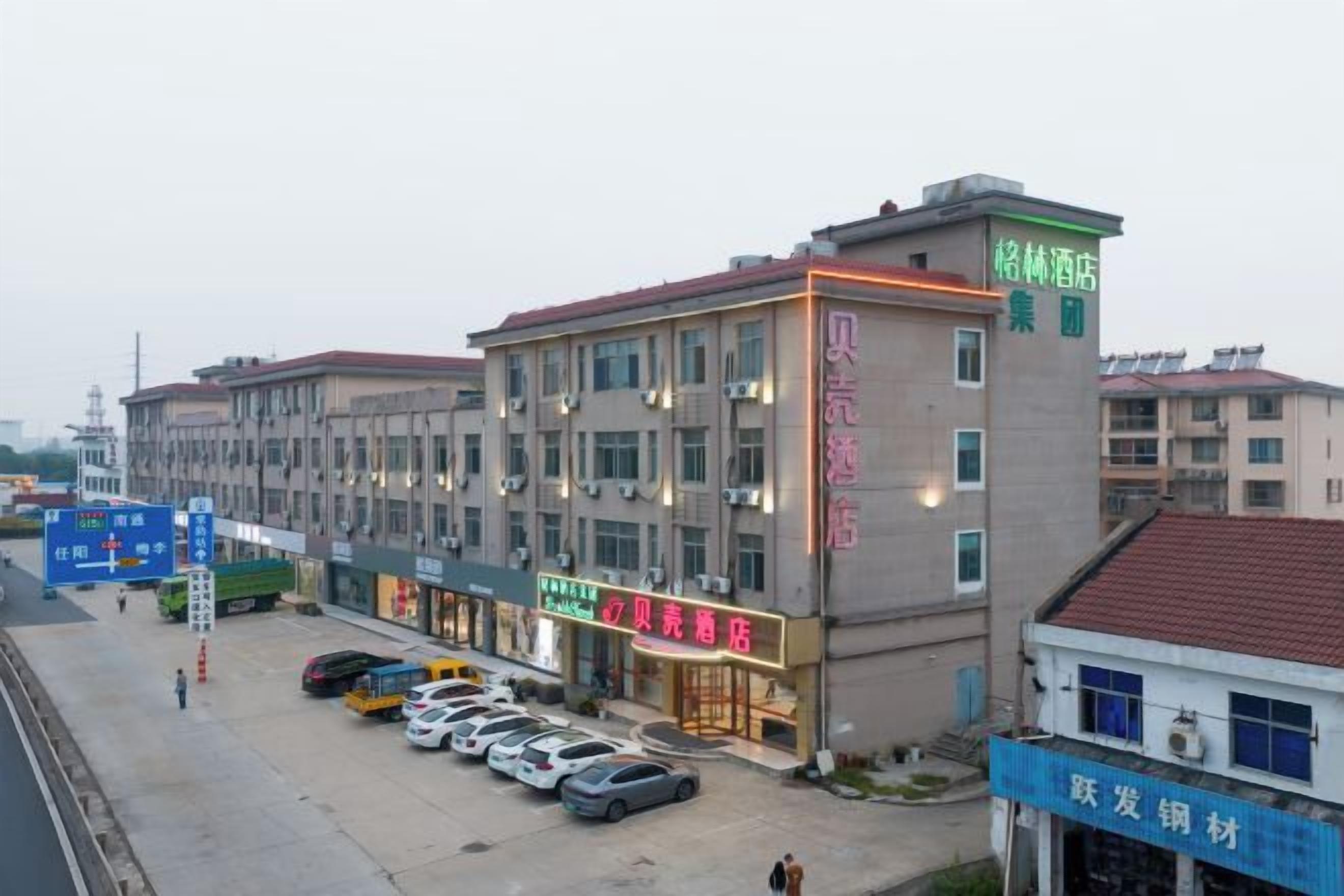 A multi-story hotel with a parking lot in front.