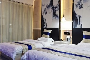 A hotel room with two beds, a large mirror, and artwork on the walls.