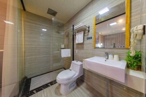 Un baño moderno con cabina de ducha de vidrio, inodoro blanco y lavabo con espejo.