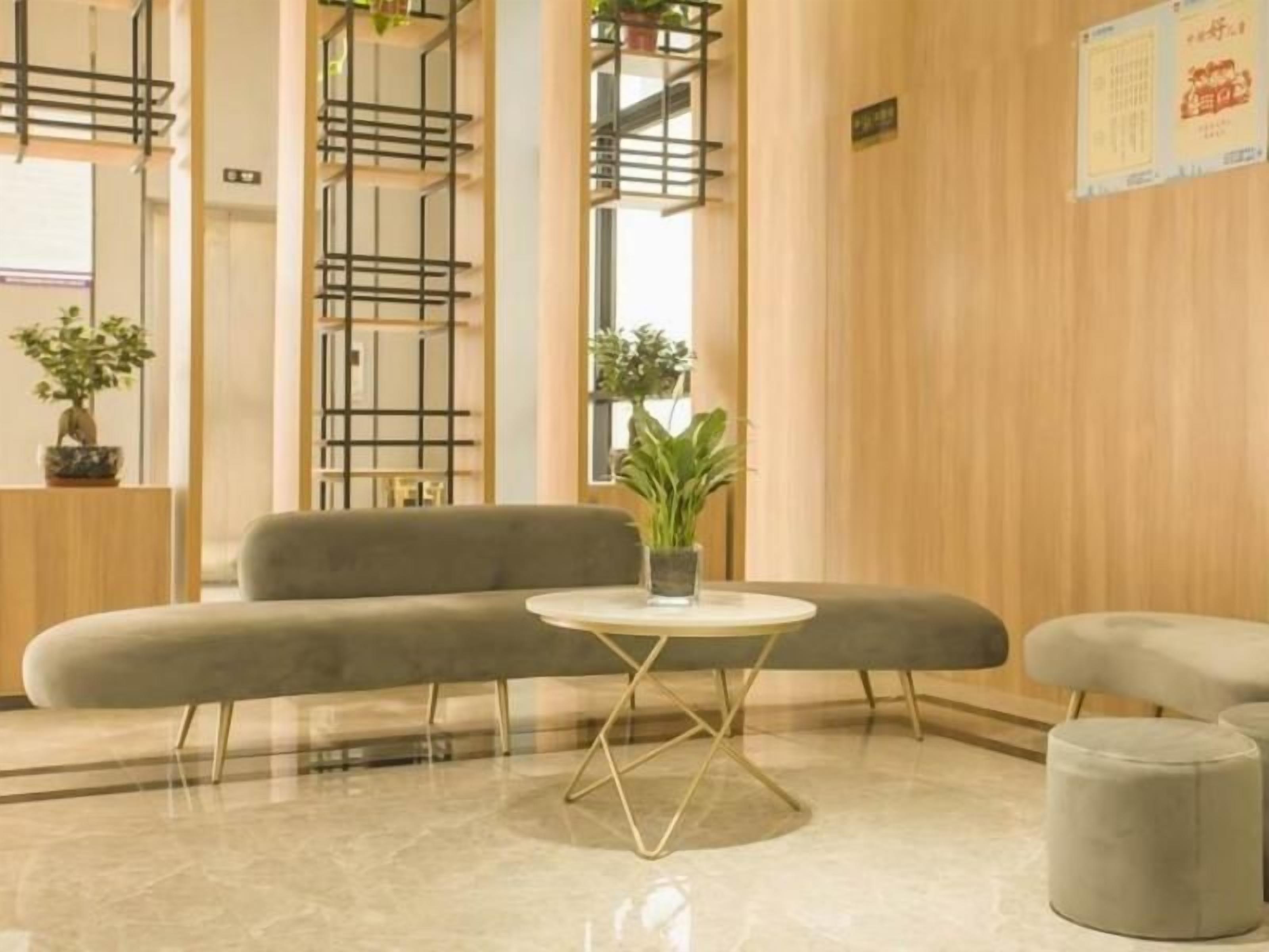 A modern lobby with a grey sofa, a small round table, and a potted plant.