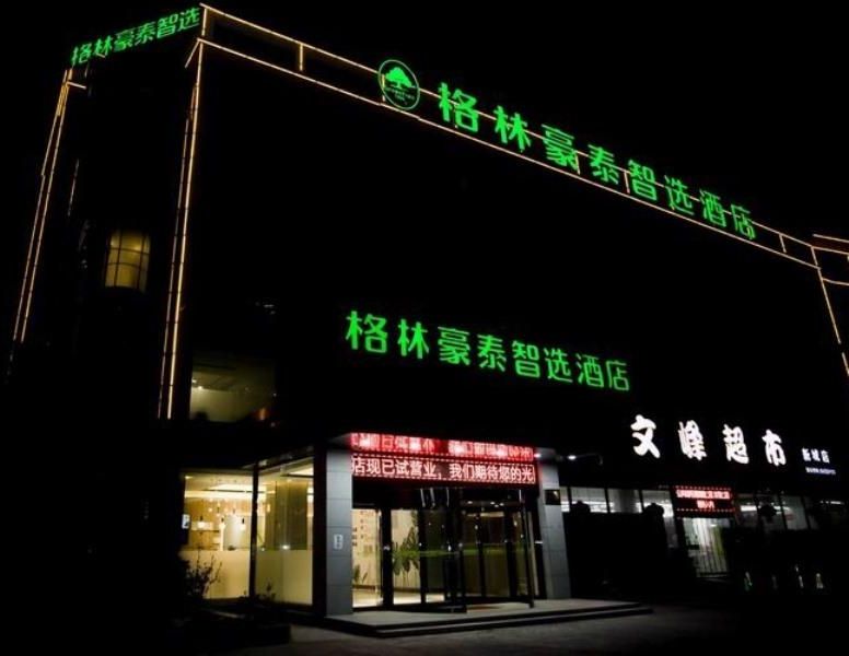 A hotel with a prominent green sign indicating it is a 'Smart Hotel'.