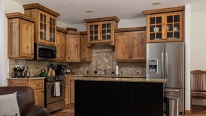 A kitchen with wooden cabinets, a stainless steel refrigerator, a microwave, and a stove. - 3BR Pet Friendly - Ski Hill Rd (Driggs)