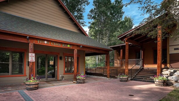 Een lodge met een bord waarop staat 'Teton Creek Resort'.