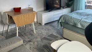 A modern bedroom with a bed, a TV, a desk, and a chair. - Apartment "Studio 2 Sea front" At the Beach with Sea View (Rincón de la Victoria)