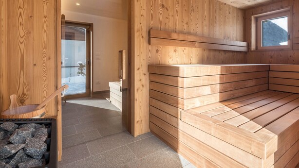 Un sauna de madera con bancos y una ventana.