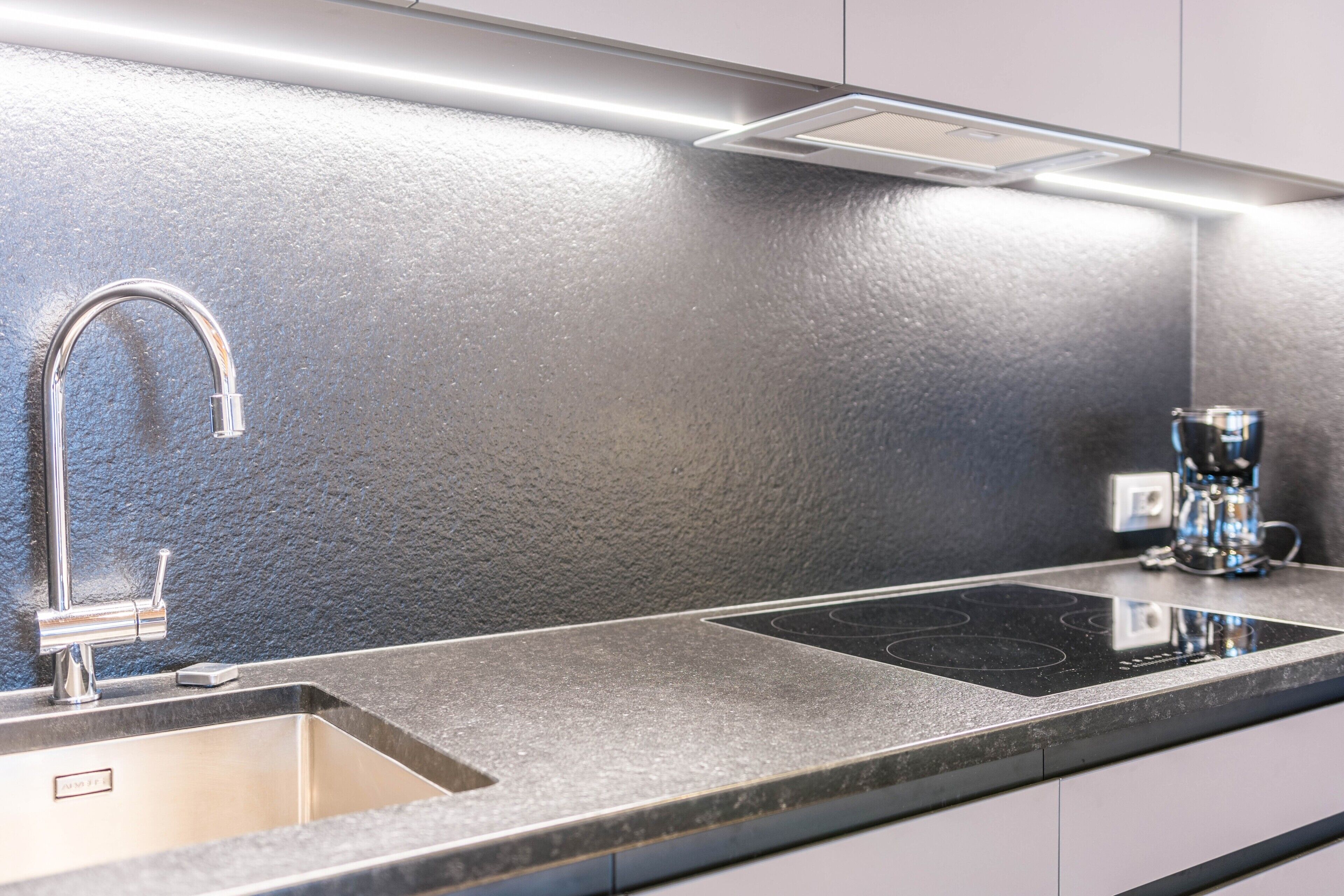 Een koelkast, een kookplaat, kookgerei, borden en bestek